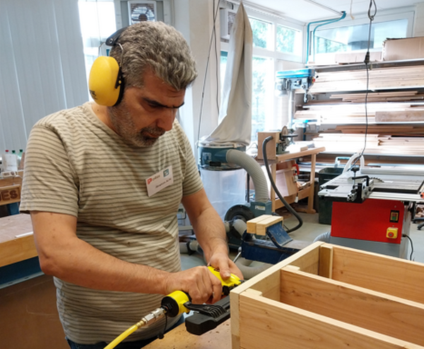 Deelnemer Ibrahim van het praktijkverklaringstraject aan de slag in de houtwerkplaats met de constructie van egelhuizen foto Stichting Piëzo