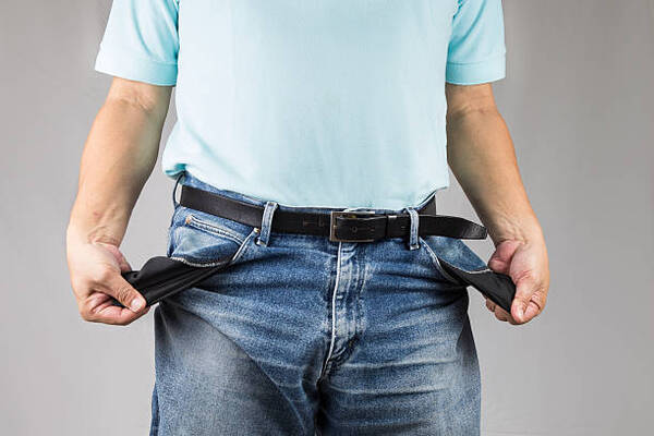 Frustrated man pulling out his empty jeans pockets.