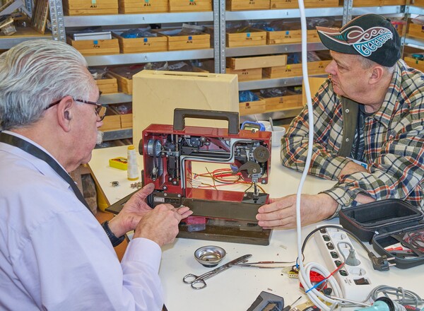 Naaimachine die door een vrijwilliger van het Repair Café wordt gerepareerd. fotograaf Leon Koppenol