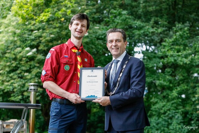 De burgemeester overhandigt de oorkonde van de gemeente aan Scoutinggroep John McCormick